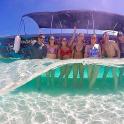 Un grupo de personas de pie en el océano con una tabla de surf.