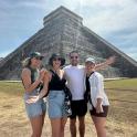 skupina lidí stojící před pyramidou