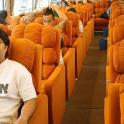 a man sitting in an orange seat on a bus