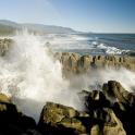 a wave crashing on the rocks near the ocean