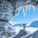 a man standing in front of an ice cave