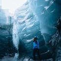 a person standing in front of an ice cave