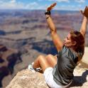 a woman laying on the edge of the grand canyon