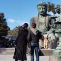 two women standing in front of a statue