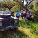 a group of people standing around a truck in a field