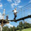 two men standing on top of a suspension wire