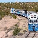 a blue and white train traveling down the tracks