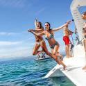 a group of women jumping off of a boat