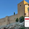 a cell phone with a statue in front of a wall