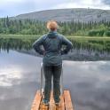 a woman standing on a dock on a lake