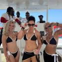 een groep vrouwen in bikini's die op een boot staan