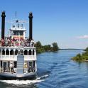 a ferry boat on a river with people on it