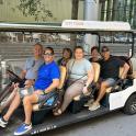a group of people sitting in a golf cart