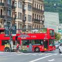 a red double decker bus on a city street
