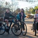 a man and two girls on bikes on a street