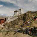 a castle on top of a mountain with prayer flags