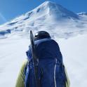 a man with a backpack and skis on a snow covered mountain