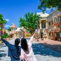 two women standing with their arms up in an amusement park