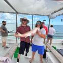 a man and woman holding a fish on a boat