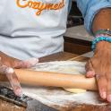a person making a dough on a wooden table