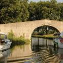 two boats in the water under a bridge
