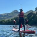 a group of people on paddle boards on a lake