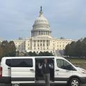 a man standing next to a white van in front of the capitol building