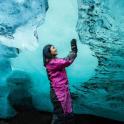 a woman is standing in front of an iceberg
