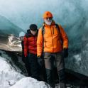 a man and woman standing in front of a glacier