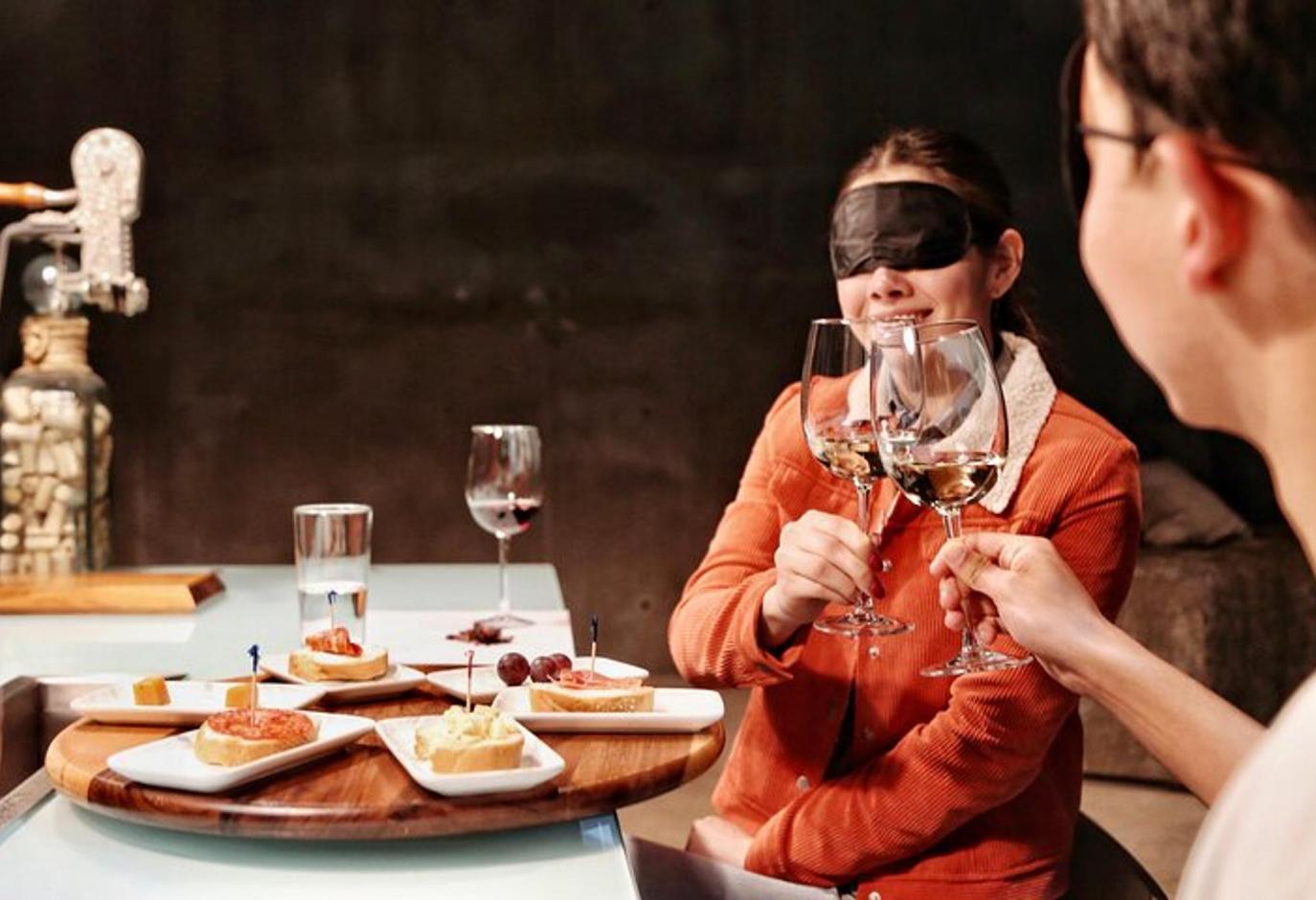 una mujer sentada en una mesa con copas de vino