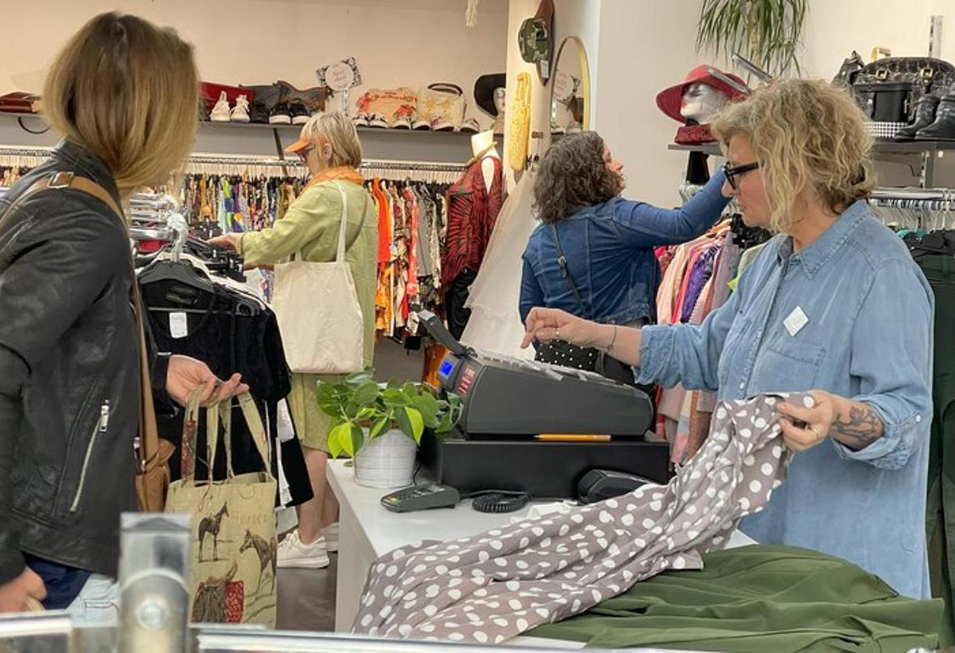 a woman standing in a store looking at clothes