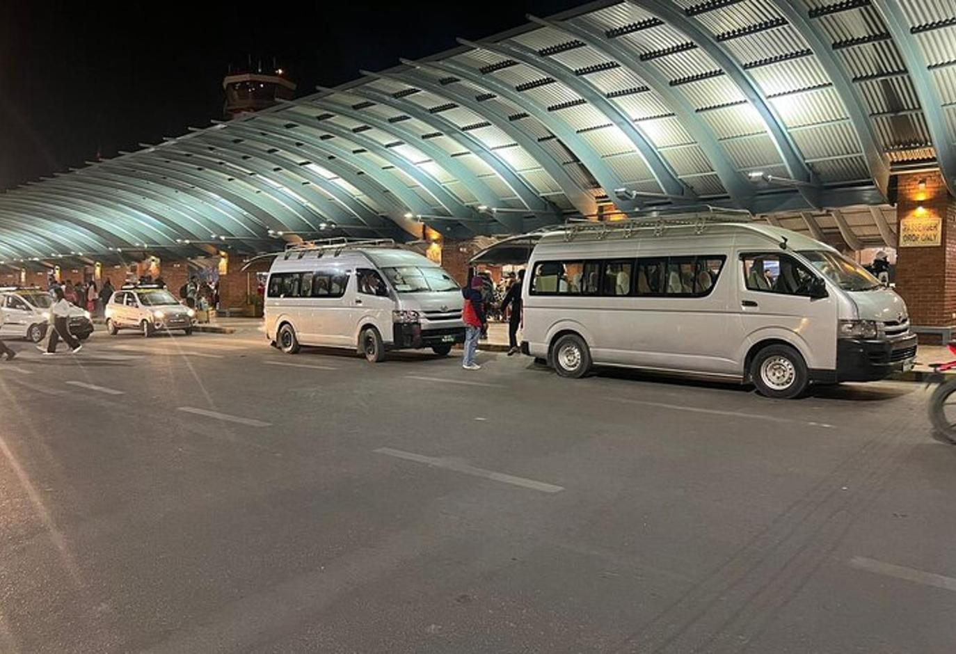 two vans parked in a parking lot at an airport