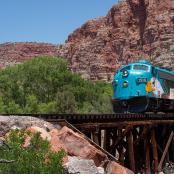 一辆蓝色火车正在穿过一座木桥