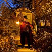 一名身着戏服的男子站在温室里