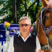 a man standing next to a brown horse