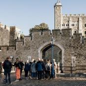 Un grupo de personas de pie frente a un castillo.