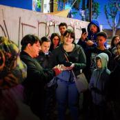 a group of people standing next to a wall