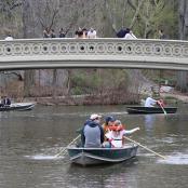 a group of people in boats on the water under a bridge