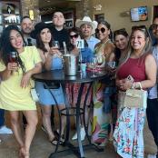 a group of people standing around a table with wine glasses