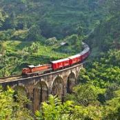 a train on a bridge over a mountain