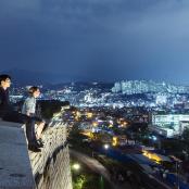 晚上,两个年轻人坐在建筑物边缘