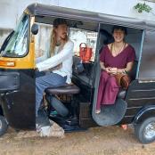 dvě ženy sedící v zadní části malého vozidla