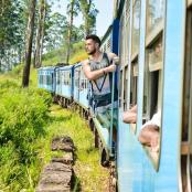 a man looking out the window of a blue train