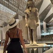 一名女子走过一栋建筑的雕像前