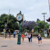 a clock on a pole in the middle of a street