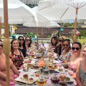 a group of women sitting around a table with food