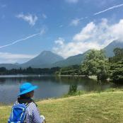 a woman with a blue hat standing next to a lake