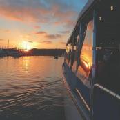 a boat on the water with the sunset in the background