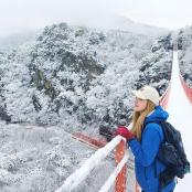 一名女子站在雪地里的吊桥上