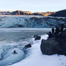 a group of people standing on a glacier in the snow